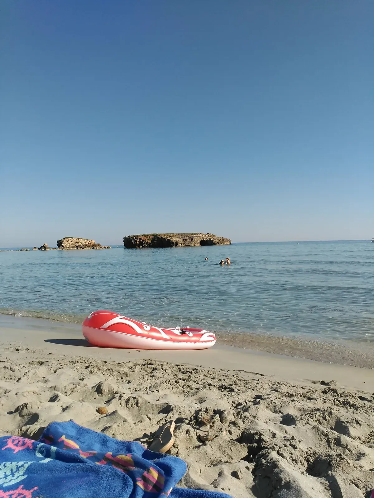 Strand von Santo Tomás am frühen Morgen, mit der Felseninsel davor und ruhigem Wasser